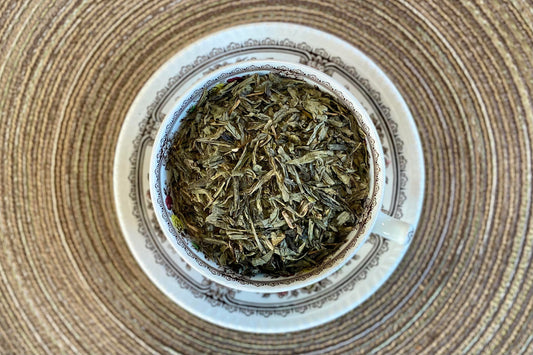 teacup full of green tea leaves