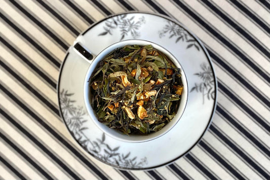 teacup full of black and white tea with citrus peel