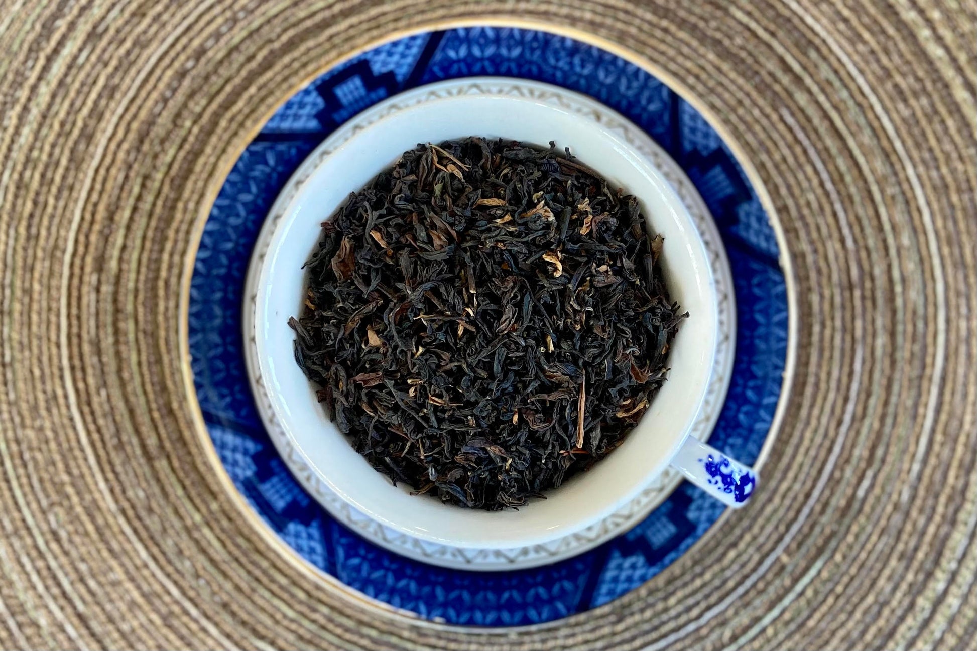 teacup full of black tea with scattered golden tips