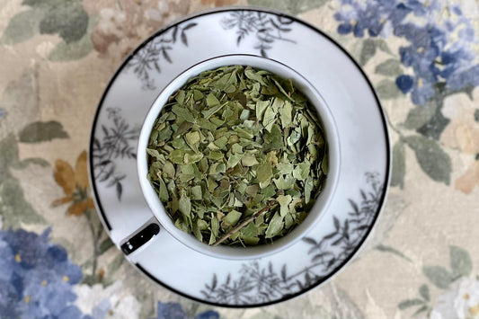 Teacup full of green leaves