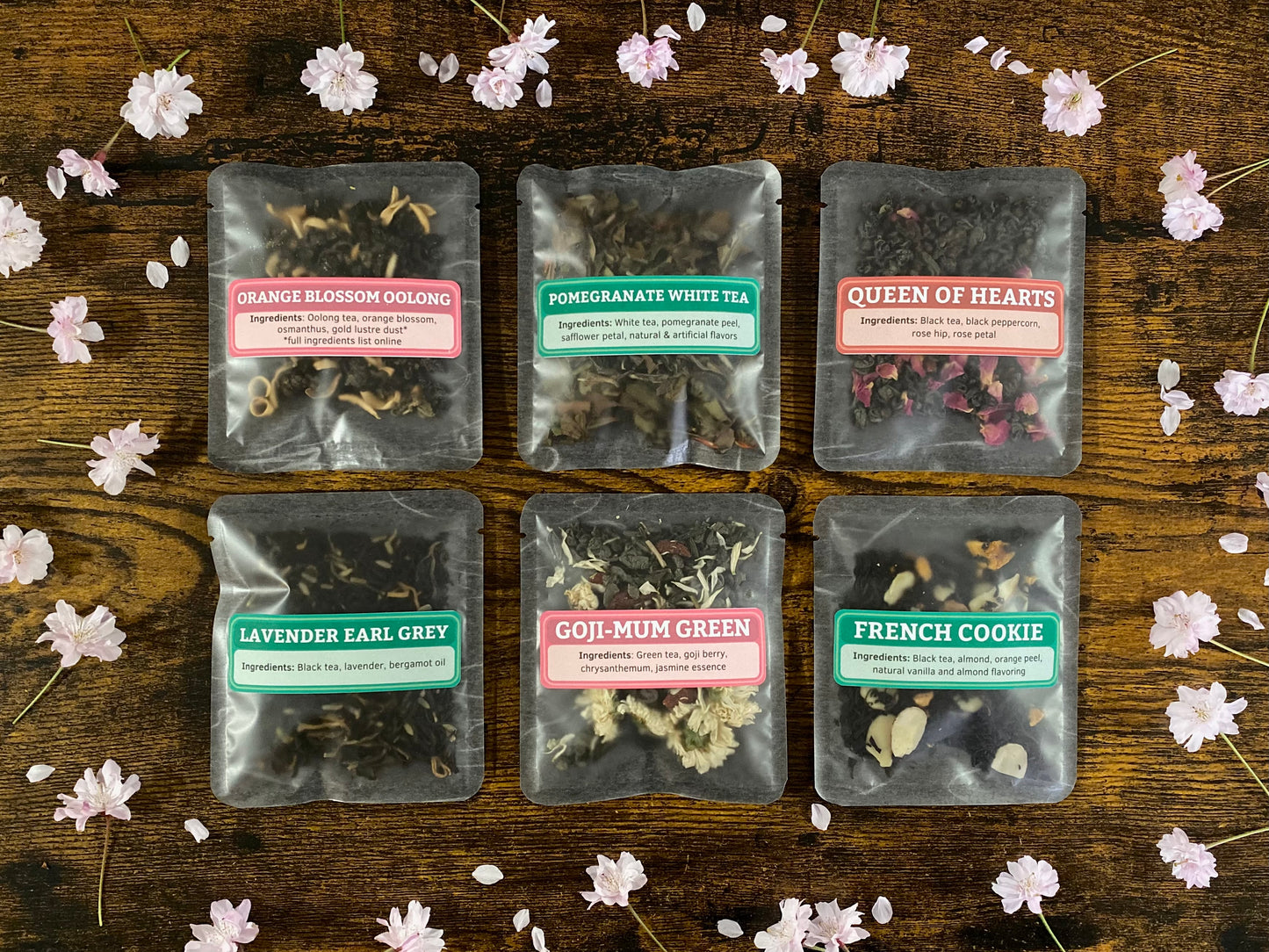 Packaged teas on a wooden surface with flowers around