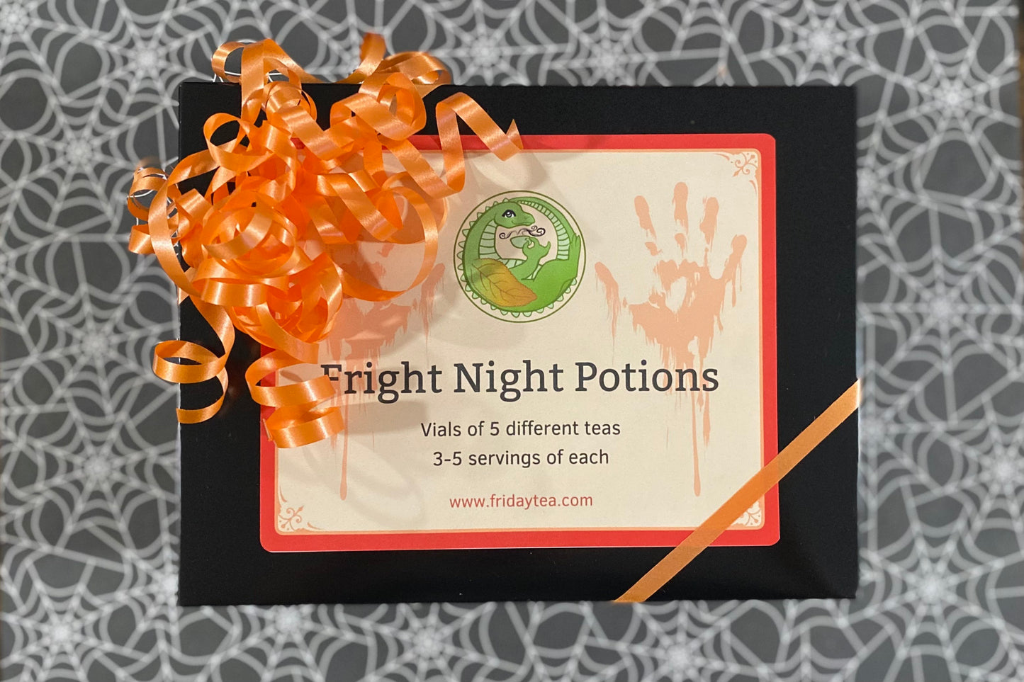 Box of 'Fright Night Potions' with a decorative ribbon on a patterned background