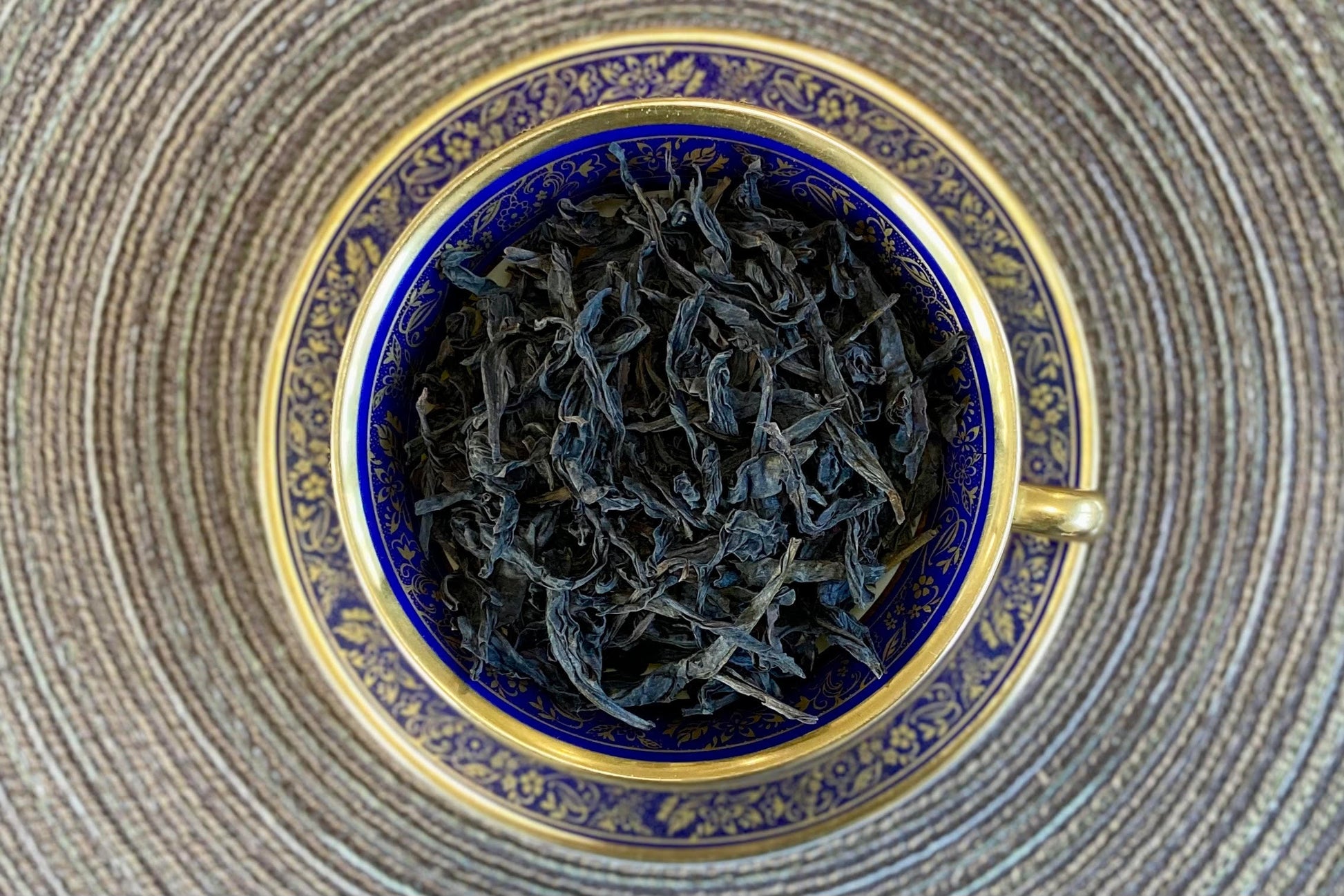 teacup full of twisted dark brown tea leaves