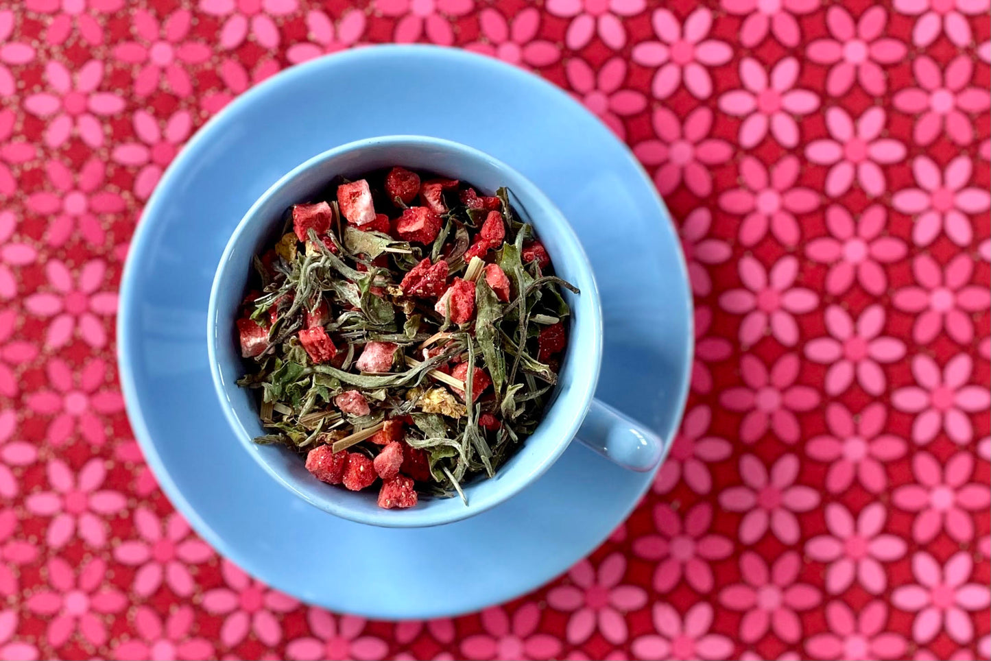 teacup full of white tea and glittery strawberry pieces