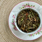 Teacup full of white tea leaf with safflower petals