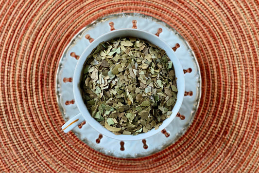 teacup full of green-brown leaves