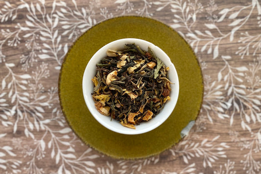Teacup of tea leaves, flowers and citrus