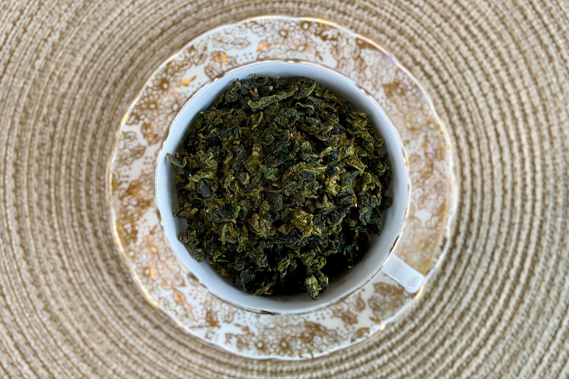 teacup full of rolled green oolong leaf