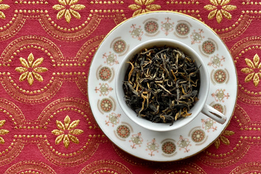 teacup full of large half-black, half-gold tea leaves