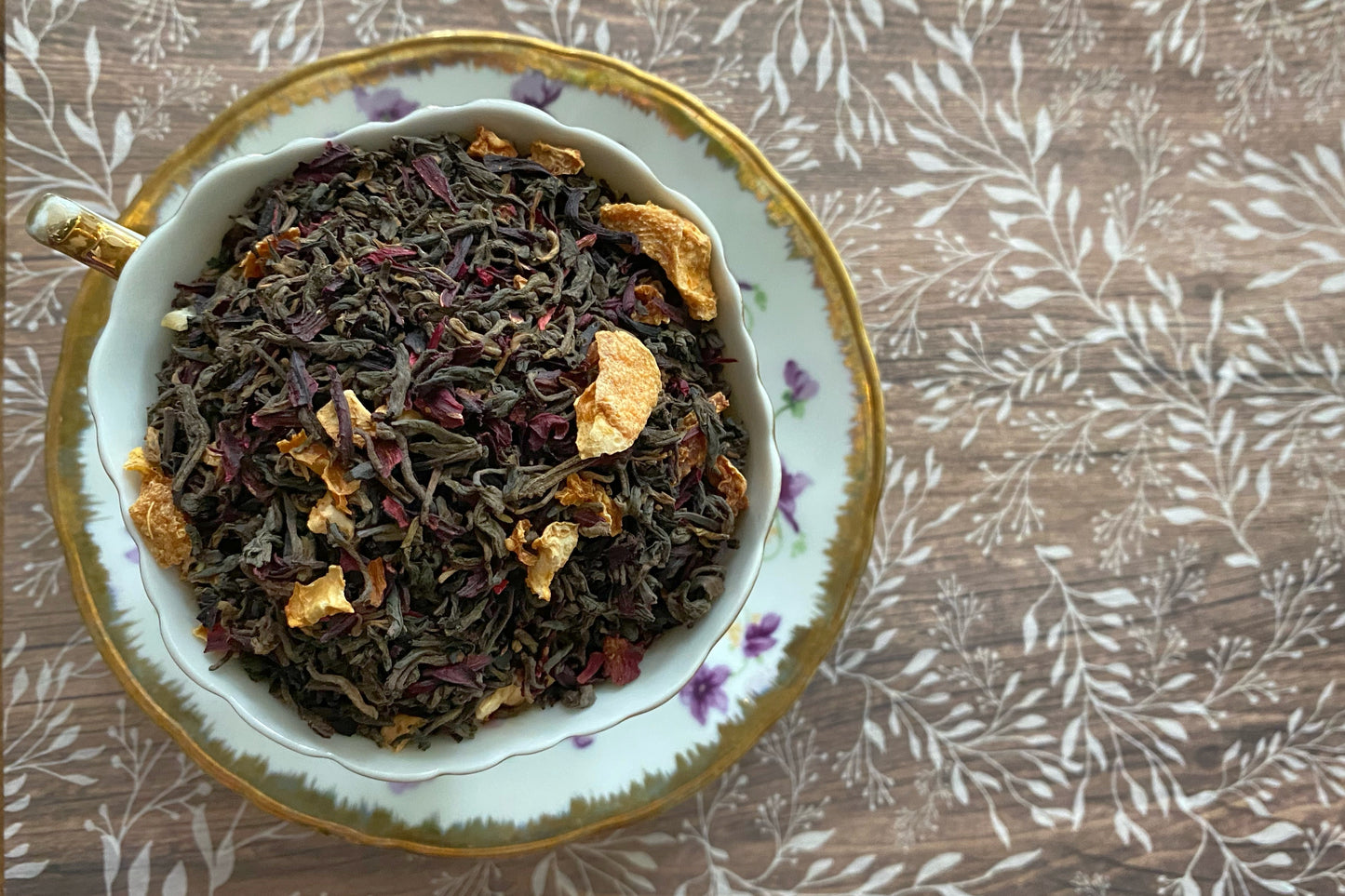 Teacup full of dark tea, citrus, and hibiscus