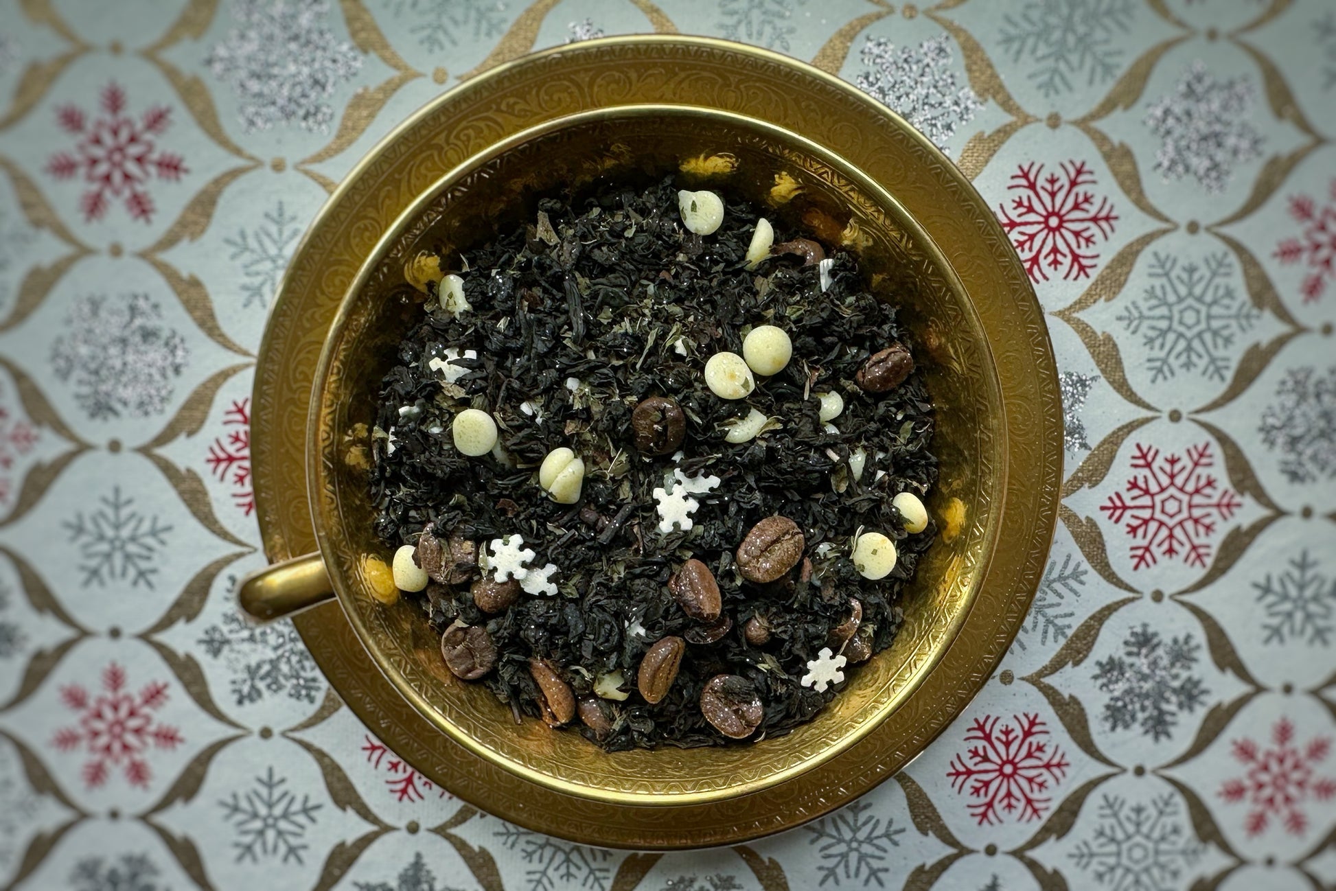 Tea leaves in a gilded teacup on a patterned surface