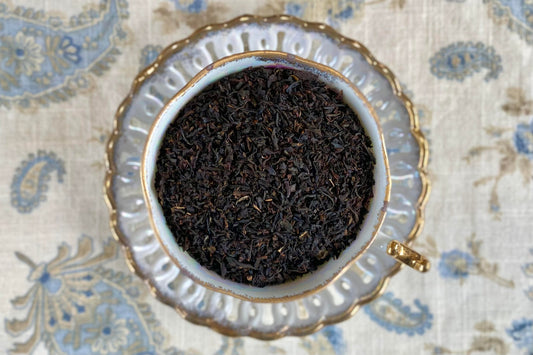 teacup full of black tea leaves