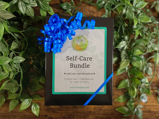 Self-care bundle with a blue ribbon on a wooden surface with green leaves