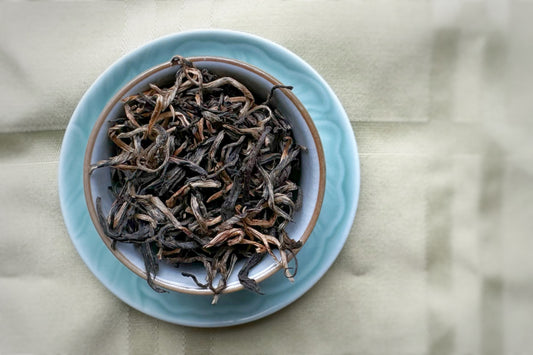 A teacup full of curly gold tea leaves