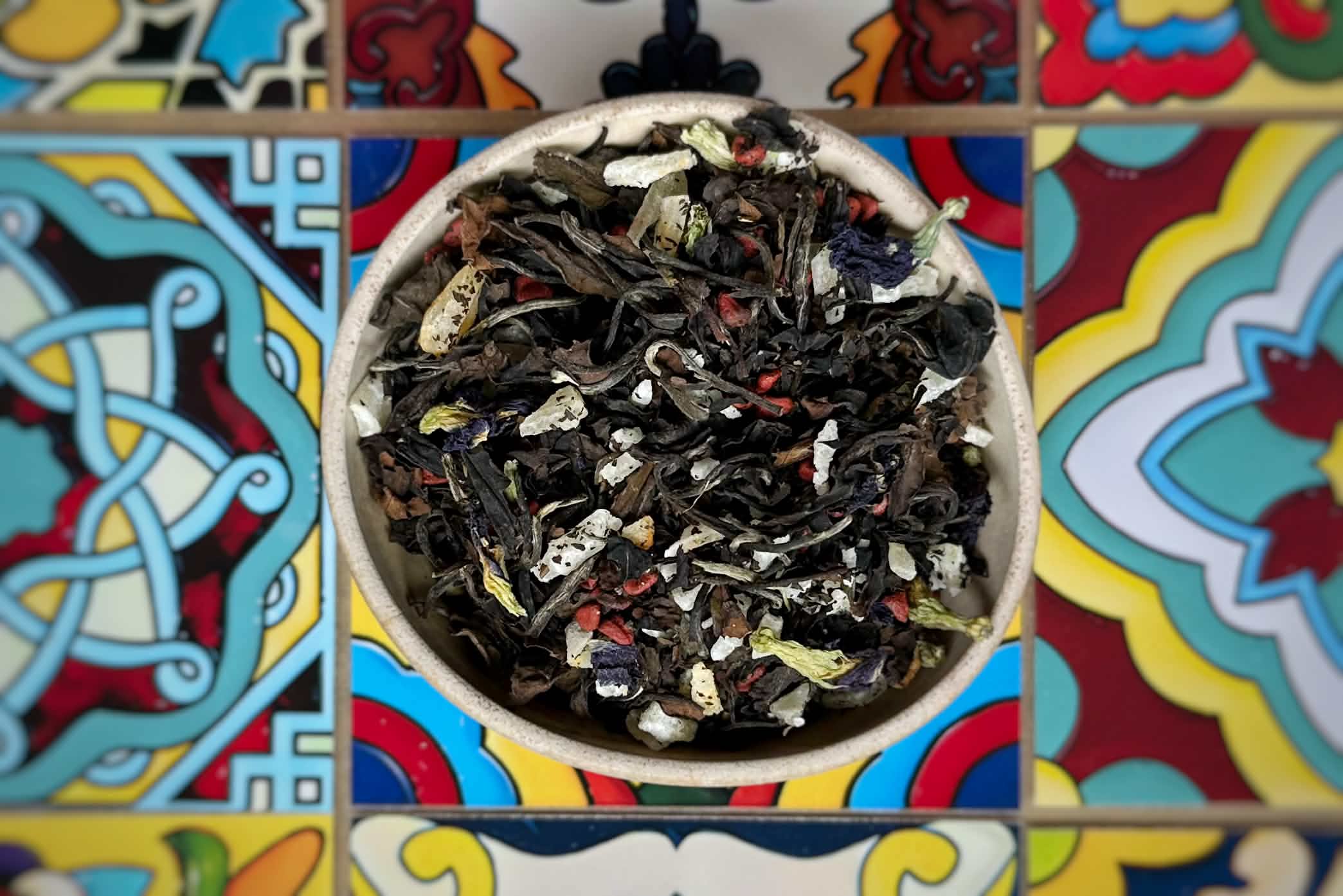 Tea leaves in a bowl with a colorful mexican talavera patterned background