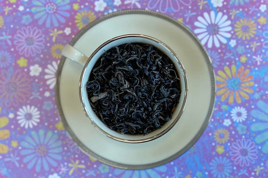 teacup full of purple tipped green tea leaf