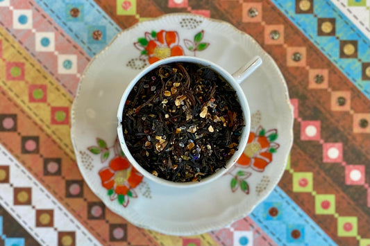 teacup full of black tea, lime peel, and rainbow sugar sprinkles