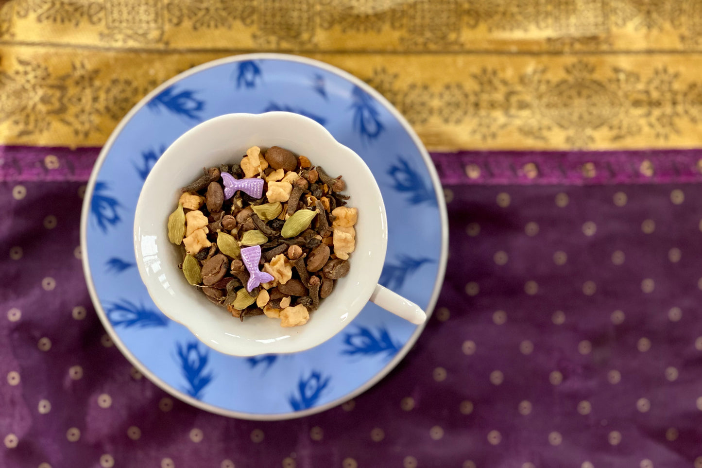 teacup full of spices, coffee beans and purple mermaid tail sprinkles