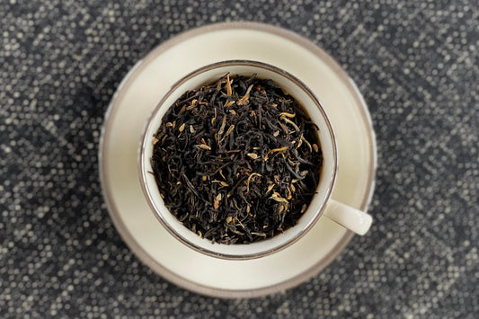 teacup full of gold-tipped black tea and anise seed