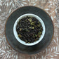 Teacup full of black tea blended with rolled green oolong