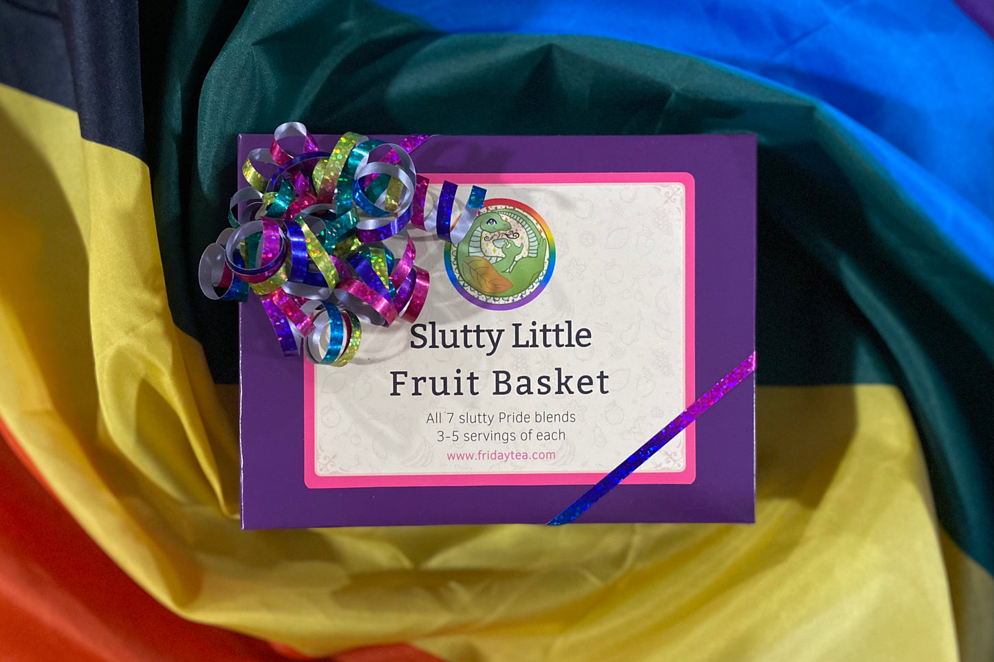 Purple box with rainbow glitter ribbon labeled "Slutty Little Fruit Basket"