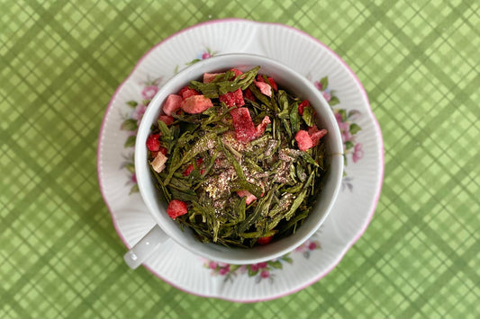 teacup full of green tea with strawberries