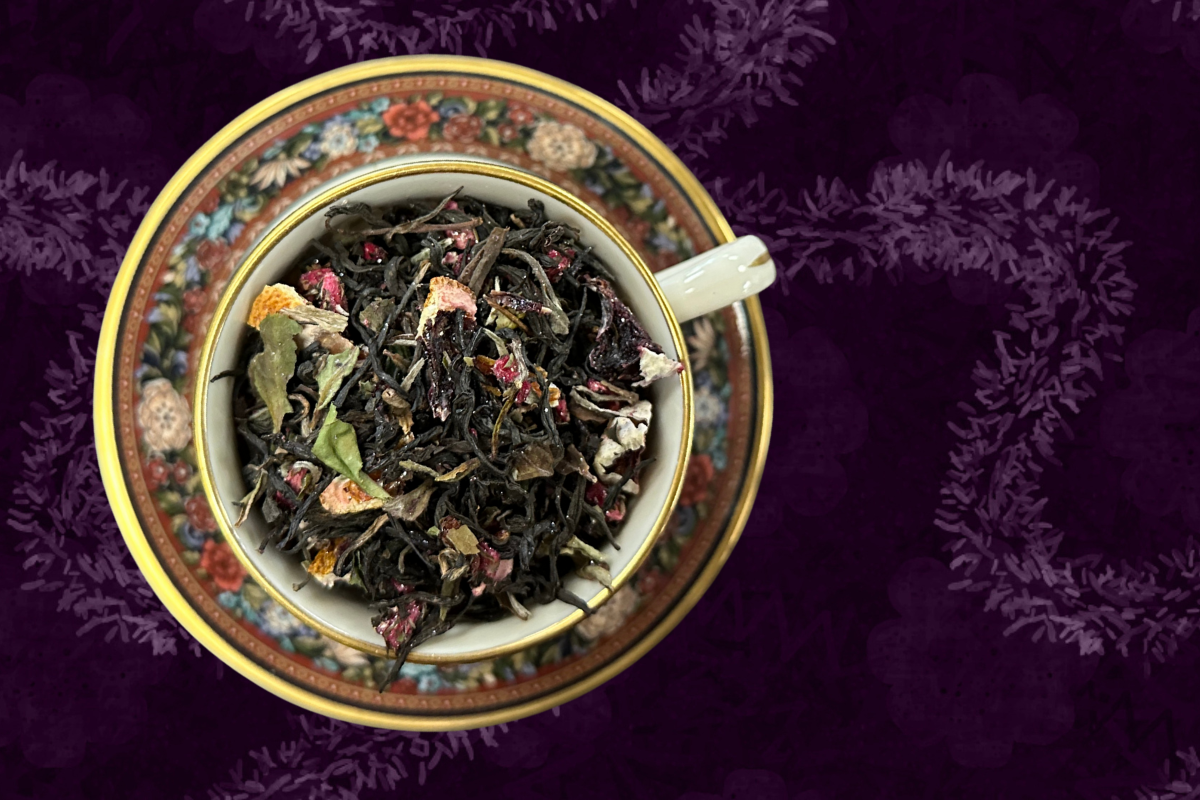 Teacup full of black and white tea with blood orange slices and purple edible glitter