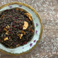 Teacup full of dark tea, citrus, and hibiscus